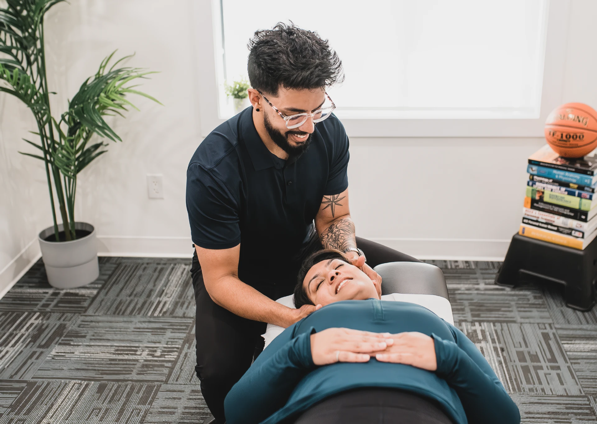 Danny Dhesa, a chiropractor, adjusts a patient's neck in a clinic.